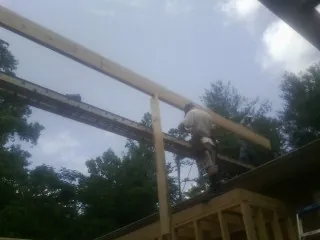 Carpenter setting a ridge beam over a new addition frame — Ice Dam Removal by Roofing Brothers in Rocky Top