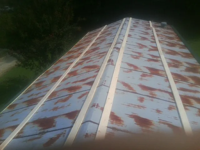 Rusted metal roof panels with new wood purlins before replacement — Storm Damage Roof Repair in Rocky Top by Roofing Brothers