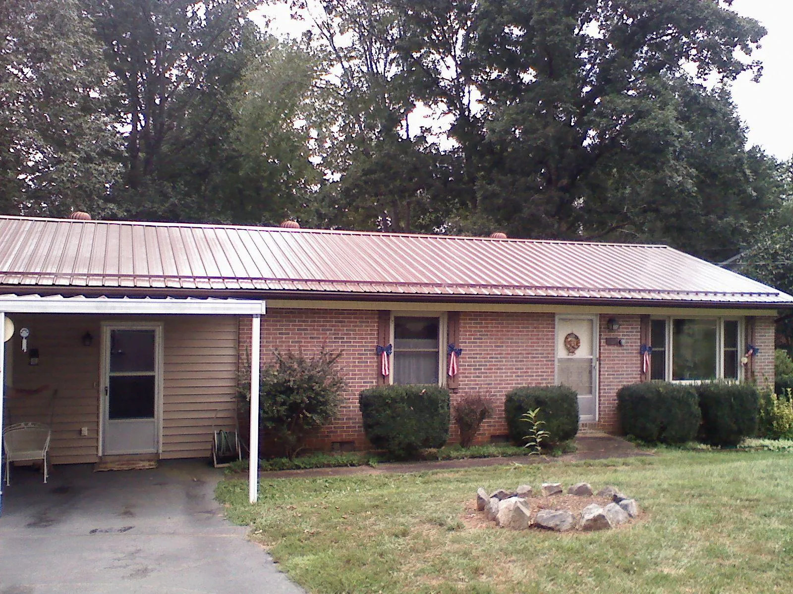 Bronze metal roof and carport on a brick ranch home — Roof Repair work by our crew in Rocky Top