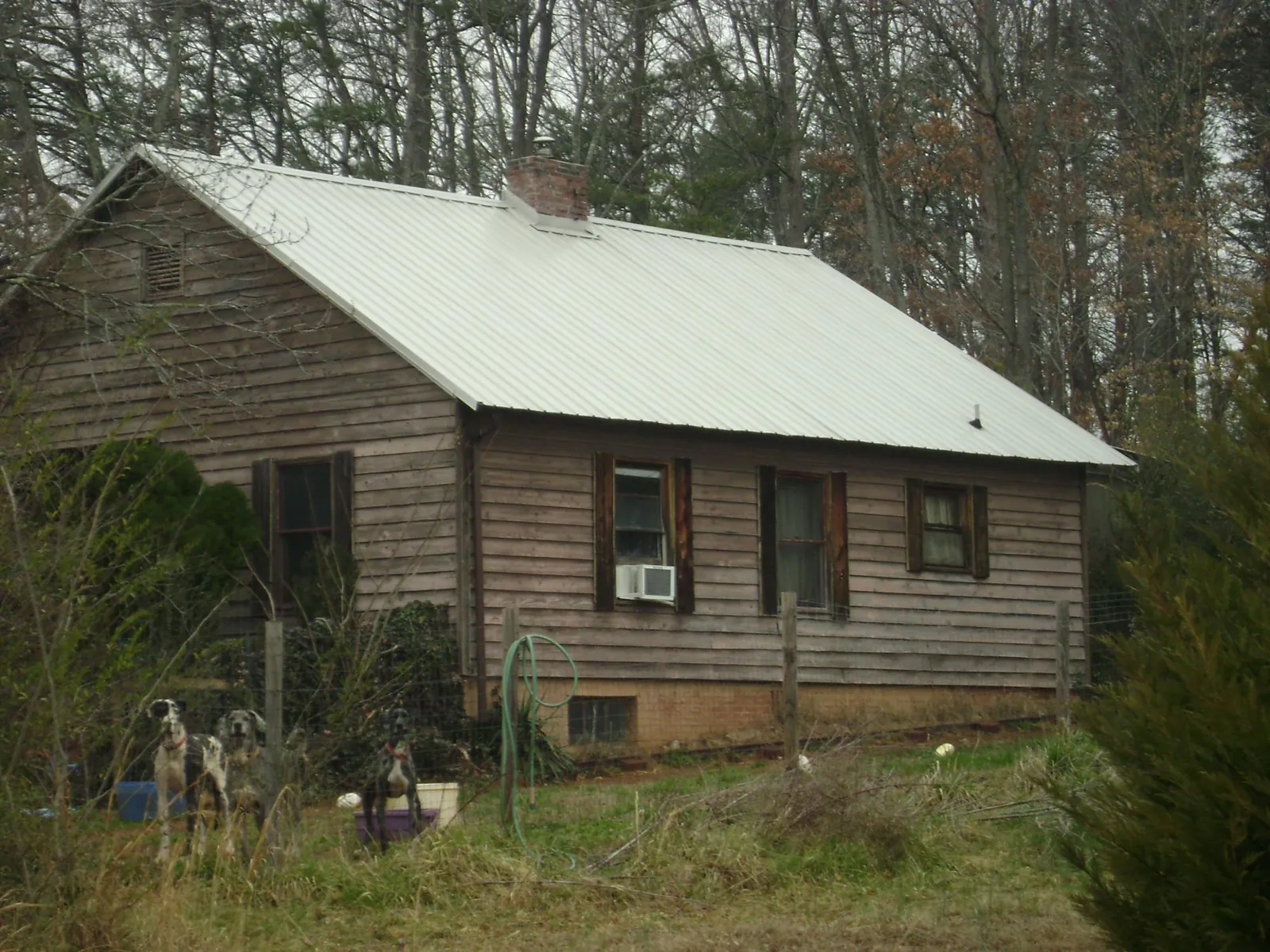 White metal roof on an old wood sided farmhouse, from a Metal Roof Installation job in Rocky Top